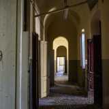 Ritorniamo sui nostri passi e ci facciamo strada tra i bui corridoi sui quali si aprono le porte in legno delle aule...